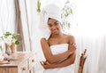 Self Care Day. Beautiful african girl wrapped in towel posing in bedroom
