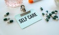 Self Care text concept write on sticker notebook with pils. Royalty Free Stock Photo