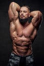 Self confident bodybuilder posing in dark background