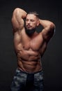 Self confident bodybuilder posing in dark background