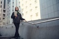 Successful motivated self-confident woman freelancer walking down the stairs of modern high-rise corporate business center with a Royalty Free Stock Photo