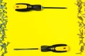 Self-cutters and two yellow screwdrivers on a yellow background with room for text. Banner with insides and fittings for a