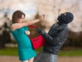 Self defense concept. Young woman is spraying with pepper spray on thief Royalty Free Stock Photo