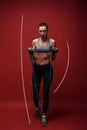 Born to win. Beautiful sportswoman performs exercises with resistance band over red background. Graphic drawing.