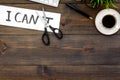 Self-doubt concept. Fight against self-doubt. Sciccors close the letter t of written word I can`t. Office desk. Dark Royalty Free Stock Photo