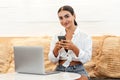 Self employed woman working with her phone and laptop in a cafe Royalty Free Stock Photo