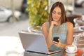 Self employed woman working with her phone and laptop in a restaurant Royalty Free Stock Photo