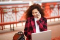 Self employed woman working with her phone and laptop in a restaurant terrace Royalty Free Stock Photo