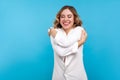 Self-esteem, love. Portrait of egoistic beautiful woman embracing herself. isolated on blue background