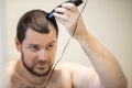 Self haircut, man shaving his head with a trimmer Royalty Free Stock Photo