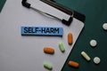 Self - Harm text on sticky notes. Office desk background. Medical or Healthcare concept