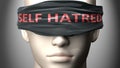 Self hatred can make things harder to see or makes us blind to the reality - pictured as word Self hatred on a blindfold to