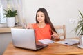 Self-isolated girl talking to teacher online and doing homework, watching webinar at laptop.  Distance education, homeschooling, E Royalty Free Stock Photo
