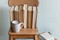 Self isolation, stay home, Hot coffee or tea, cocoa, chocolate cup and old books on wooden chair. Concept of stydy education, time
