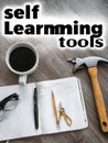 Self Learning Tools on a Wooden Table Featuring Coffee, Stationery, and a Hammer Royalty Free Stock Photo