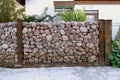 Self-made fence made of stones. A specific form of a gabion made of pebble stones