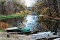 Self-made, wooden pier from the old boards on the lake, near are the boats, the river in the mud, duckweed Royalty Free Stock Photo