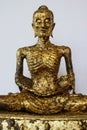 Self-mortification Buddha statue with gold leaf attached to the body Royalty Free Stock Photo