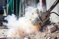 self-operating jackhammer breaking through a concrete wall at demolition site