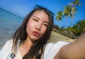 Self portrait of gorgeous beautiful and happy Asian Korean or Chinese woman 20s taking selfie photo sending kiss with mobile phone Royalty Free Stock Photo