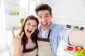 Self-portrait of his he her she two nice attractive crazy positive cheerful spouses cooking domestic dish showing horn