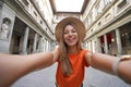 Self portrait of young tourist woman in courtyard of historic Uffizi Gallery art museum in Florence, Tuscany, Italy