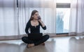 Self-quarantined woman with phone and laptop sitting on floor