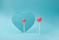 Self reflection concept with pink lollipop looking in heart mirror on minimal artistic blue background