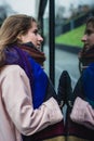 Self reflection portrait of amazing young girl in mirrored window. Unusual strange pretty woman person with sensual face looking Royalty Free Stock Photo