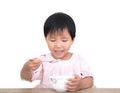 The self-reliant child in front of a white background is eating by himself Royalty Free Stock Photo