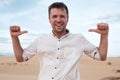 Self-satisfied and proud caucasian young man looks forward showing with index fingers on himself Royalty Free Stock Photo