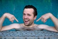 Proud caucasian young man looks forward showing with index fingers on himself. He is swimming in pool during vacation Royalty Free Stock Photo