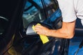 Self-service car wash. A man wipes the mirror on his car with a rag Royalty Free Stock Photo