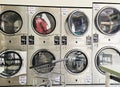 Self-service laundry automatic washing machines with clothes inside at laundromat. Royalty Free Stock Photo