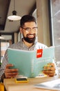 Positive bearded man studying a new language by himself