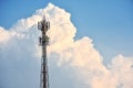 Cellular transmission tower with white clouds and blue sky background. Royalty Free Stock Photo