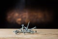 Self-tapping screws falling on plywood on a wood background, black, chromed and yellow Royalty Free Stock Photo