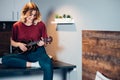 Self-taught woman playing ukulele at home Royalty Free Stock Photo