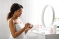 Selfcare Concept. Smiling African American Woman Applying Moisturising Cream At Home Royalty Free Stock Photo