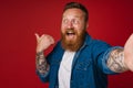 Selfie of adult bearded tattooed handsome smiling redhead man