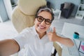 Selfie cadre of showing her workplace funny pensioner businesswoman thumb up showing respect employer isolated on office Royalty Free Stock Photo