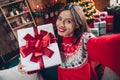 Selfie closeup portrait photo of cheerful rejoicing girl shooting her with new santa claus giftbox christmas tree behind