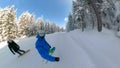 SELFIE: Cool male and female snowboarders snowboarding down the groomed slope.