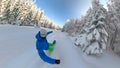 SELFIE: Cool snowboarder snowboarding down the groomed slope and past a forest.