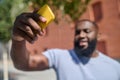 A dark-skinned man in a white tshirt making selfie