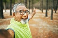 Selfie, excited and senior man hiking for health, wellness or cardio training on a mountain. Smile, nature and happy