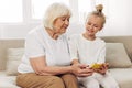 Togetherness grandmother selfie hugging sofa smiling family granddaughter phone bonding child Royalty Free Stock Photo