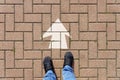 Selfie of feet and arrows on the road. top view. Businessmen in black shoes standing on a road with many white arrow pathway sign