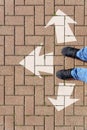 Selfie of feet and arrows on the road. top view. Businessmen in black shoes standing on a road with many white arrow pathway sign