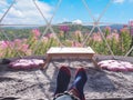 Selfie feet on bed at resort over flower field and green mountain background